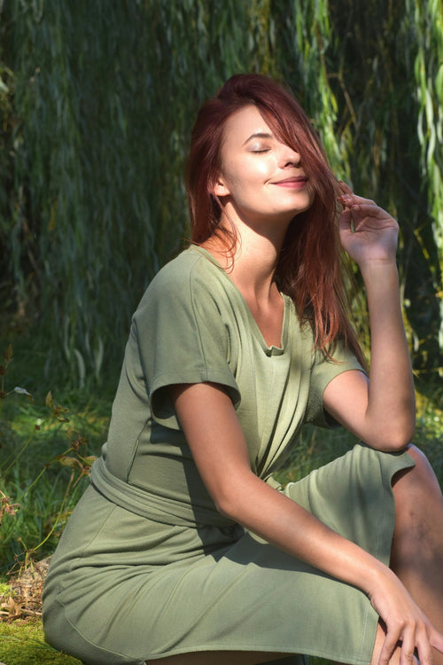  Portrait d’une femme en robe verte à l’extérieur dans un paysage verdoyant. 